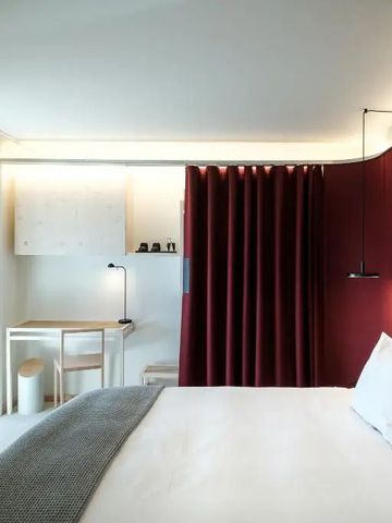 Stilvolles Zimmer mit roter Akzentwand und elegantem Schreibtisch