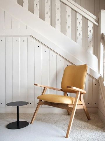 Modernes Design mit gelbem Sessel und Treppenhaus aus Holz