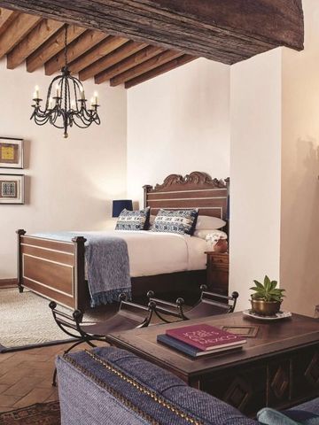 Gemütliches Schlafzimmer mit Holzbalkendecke und luxuriösem Bett in traditionellem Dekor