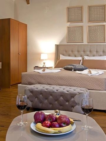 Luxuriöses Zimmer mit Doppelbett, Obst und Wein auf dem Tisch