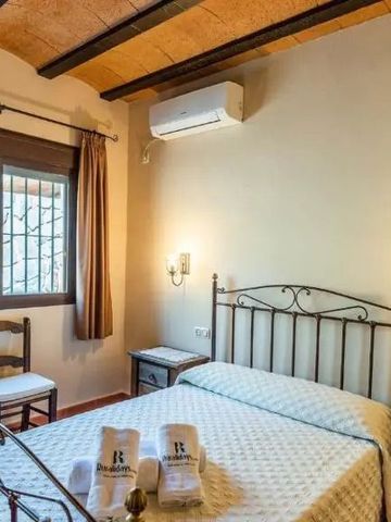 Komfortables Schlafzimmer mit hellen Vorhängen und Holzdetails