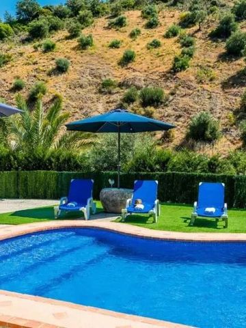 Außenpool mit Liegestühlen vor einer grünen Landschaft