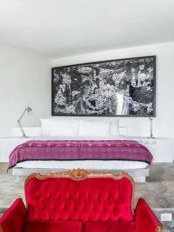 Geräumiges Zimmer mit rotem Sofa und stilvollem Kunstwerk