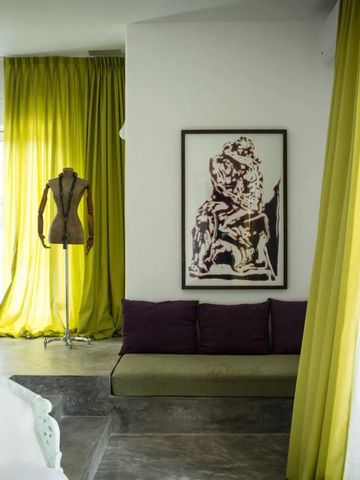 Helle Einrichtung mit grünen Vorhängen und Kunstwerk im Hotelbereich