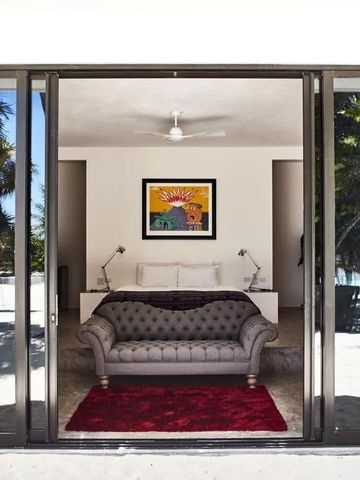 Blick von Terrasse auf Strand mit stilvollem Interieur und Kunst