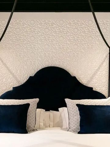 Detailaufnahme eines Bettes mit elegantem Kopfteil und blauen Akzenten.