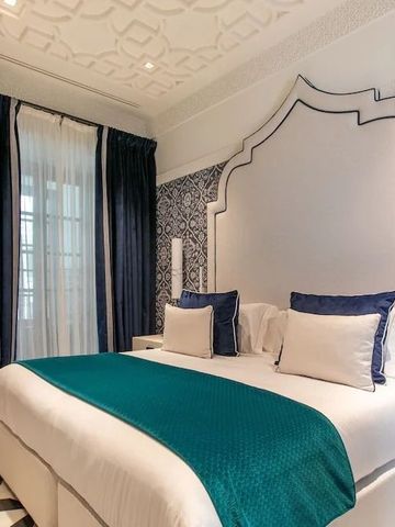 Gehobenes Hotelzimmer mit blauen Akzenten und kunstvollen Wänden