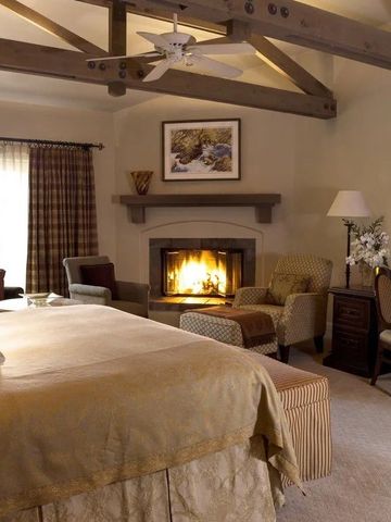 Gemütliches Schlafzimmer mit Kamin und Holzbalkendecke