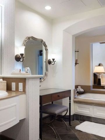 Elegant eingerichtetes Badezimmer mit großer Badewanne und Spiegeln.