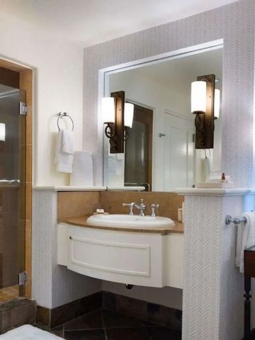 Gut beleuchtetes Badezimmer mit eleganten Armaturen und Spiegel.