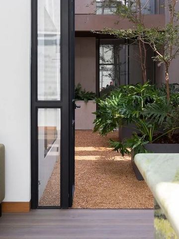 Moderne Terrasse mit Blick auf einen begrünten Innenhof