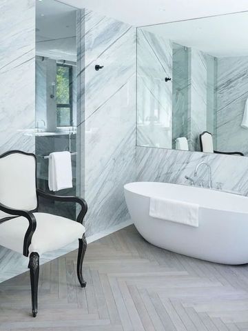 Luxuriöses Badezimmer mit freistehender Badewanne und Marmorwänden