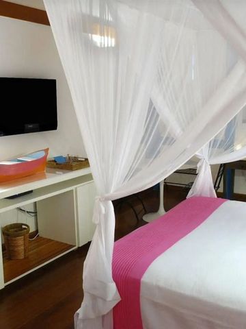 Helles Schlafzimmer mit Baldachin einem Fernseher und maritimer Dekoration