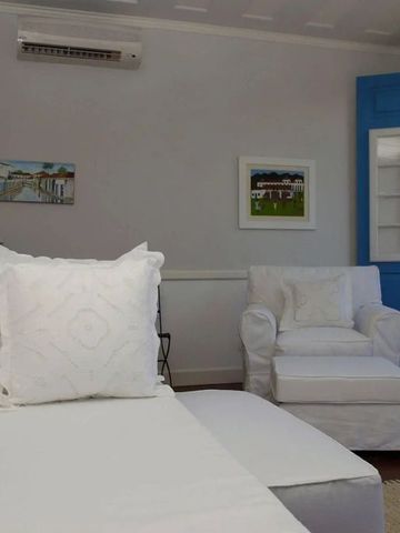 Helles Schlafzimmer mit weißen Möbeln und blauen Akzenten sowie Balkonblick