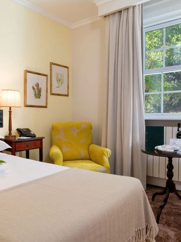 Helles Gästezimmer mit großem Fenster und gemütlichem Sessel