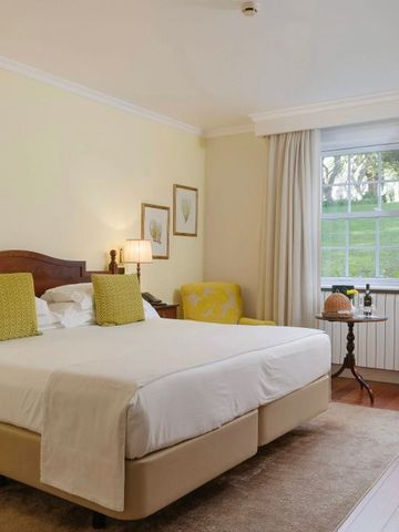 Geräumiges Schlafzimmer mit großen Fenstern und neutralen Farben