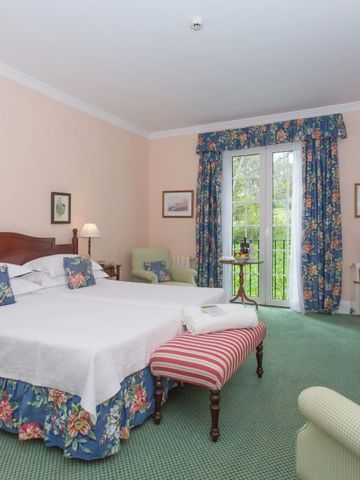 Großes Gästezimmer mit farbenfrohen Vorhängen und Balkonzugang