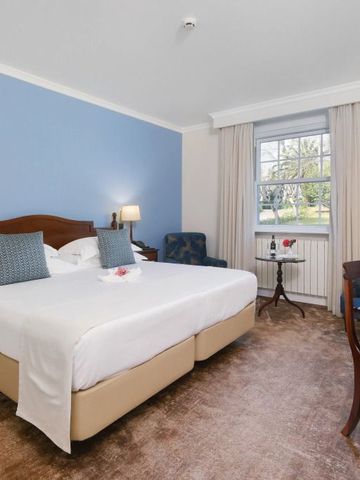 Modernes Doppelzimmer mit blauer Akzentwand und stilvollen Möbeln