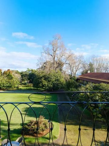 Blick aus einem Fenster mit Garten und blauem Himmel im Hintergrund