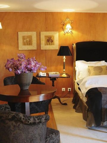 Zimmer mit Doppelbett, stilvoller Beleuchtung und gemütlicher Sitzecke