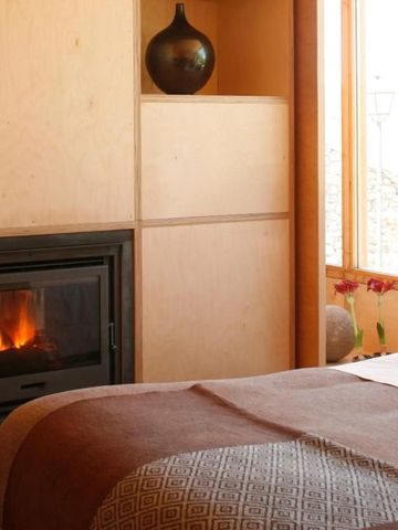 Gemütliches Schlafzimmer mit Kamin und Kingsize-Bett im Hotel Casas do Côro