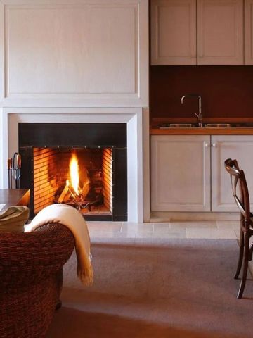 Gemütliches Wohnzimmer mit Kamin und stilvollen Möbeln in einem Hotelzimmer