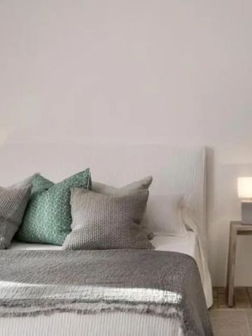 Modernes Schlafzimmer mit stilvollen Kissen und Nachttischen