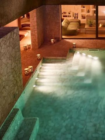 Beleuchtetes Indoor-Pool mit gemütlichen Sitzbereichen im Cascioni Eco Retreat