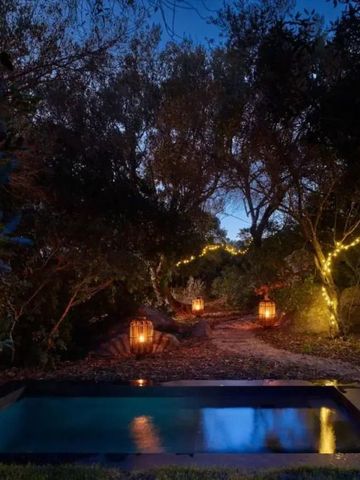 Ruhiger beleuchteter Gartenpfad mit kleinem Pool bei Nacht