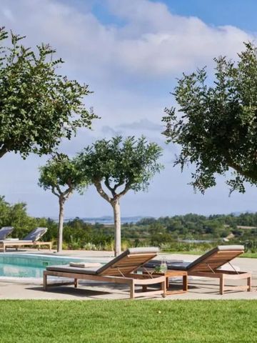 Sonnenliegen und Bäume am Pool mit Blick auf die Landschaft