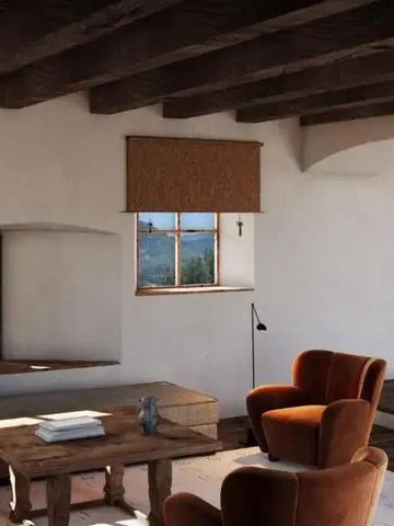 Einladendes Wohnzimmer mit Holzbalkendecke und gemütlichen Sesseln