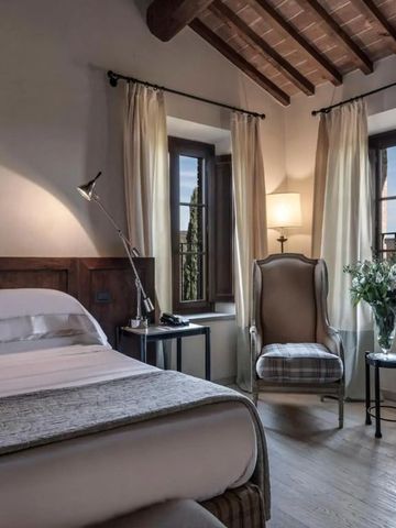 Gemütliches Hotelzimmer mit rustikalem Holzbalken und edlen Möbeln in warmem Licht.