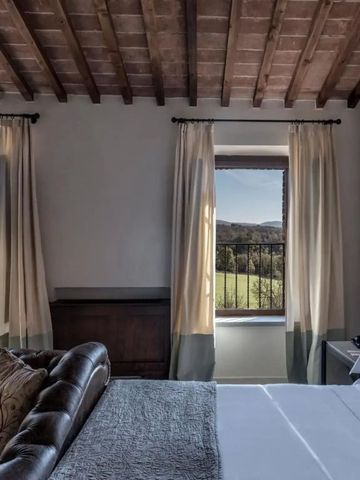Hotelzimmer mit Blick auf die toskanische Landschaft, stilvoll eingerichtet mit Naturmaterialien.