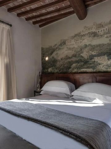 Gemütliches Schlafzimmer mit Holzbalkendecke und Wandgemälde im Castel Monastero