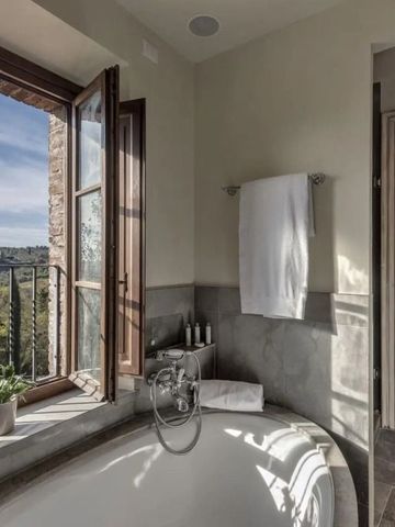 Helles Badezimmer mit Fensterblick ins Grüne im Castel Monastero