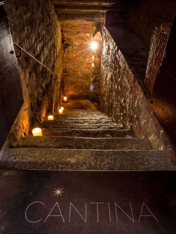 Historische Steintreppe führt zu einem stimmungsvollen Weinkeller mit Kerzenbeleuchtung
