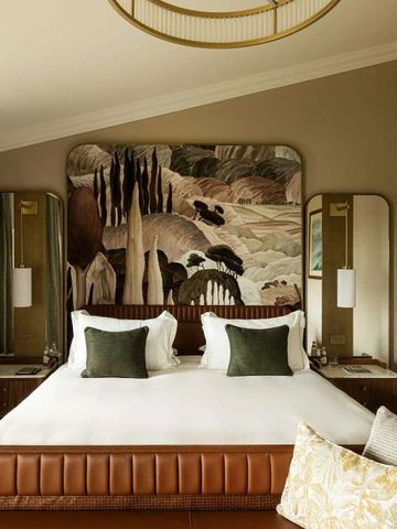 Elegantes Hotelzimmer mit großem Bett und künstlerischer Wanddekoration