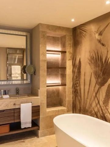 Luxuriöses Badezimmer mit freistehender Badewanne und künstlerischen Wanddetails