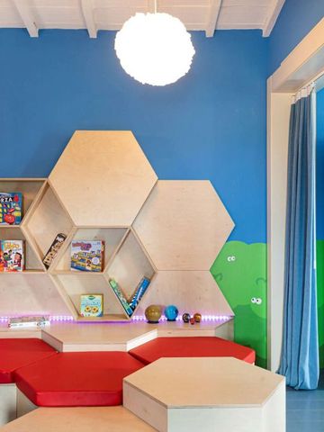 Spielzimmer für Kinder mit bunter Wand und Regalen voller Spielsachen