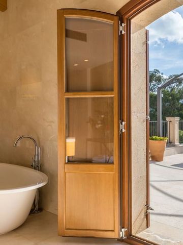 Luxuriöses Badezimmer mit freistehender Badewanne und Zugang zur Terrasse