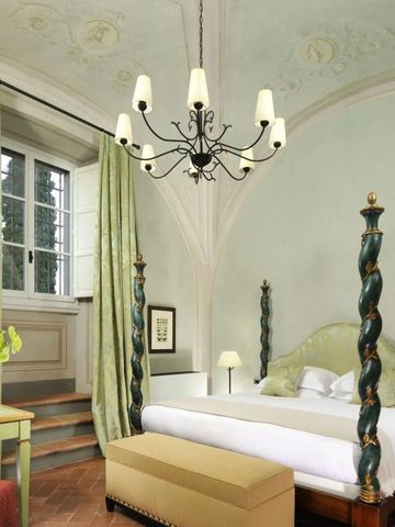 Luxuriöses Hotelzimmer mit Baldachinbett und dekorativer Decke im COMO Castello del Nero