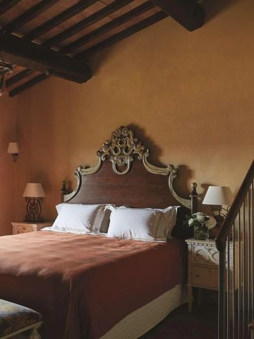 Luxuriöses Schlafzimmer mit kunstvollem Kopfteil und stilvoller Beleuchtung