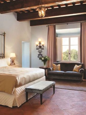 Elegantes Zimmer mit Balkendecke und gemütlicher Sitzecke im Castello di Casole