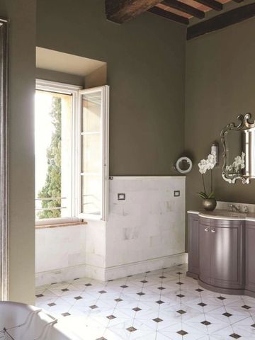 Luxuriöses Badezimmer mit großen Spiegeln und einem Fenster mit Blick ins Grüne