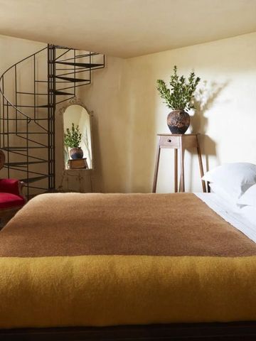 Obergeschoss-Schlafzimmer mit Wendeltreppe Spiegel und eleganter Einrichtung