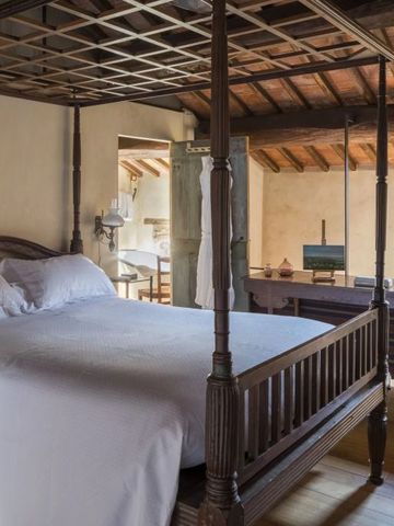 Elegantes Schlafzimmer mit Baldachinbett in rustikalem Design und Holzdach.