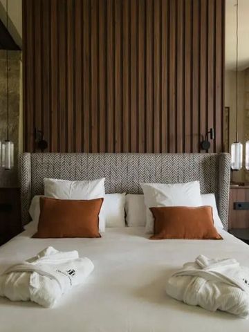 Einladendes Bett mit edlen Kissen und stilvollen Lampen