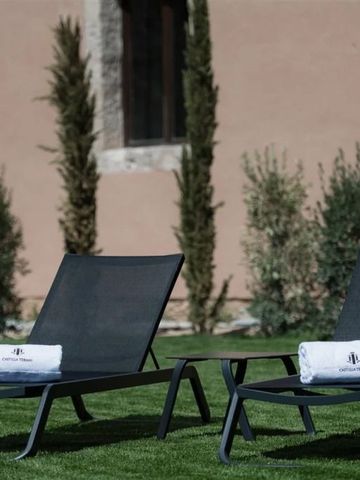 Sonnenliegen mit Handtüchern im Garten des Castilla Termal Brihuega