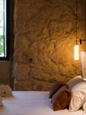 Gemütliches Hotelzimmer mit Steinwand und moderner Beleuchtung