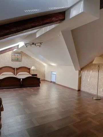 Grosszügiges Zimmer mit Holzbalken und zwei Betten unter schrägen Decken